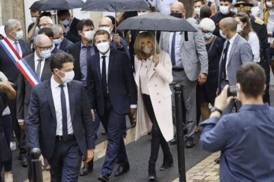 ​法国总统夫人好出彩！穿淡粉风衣搭同色衬衫，牵手老公化身小女人