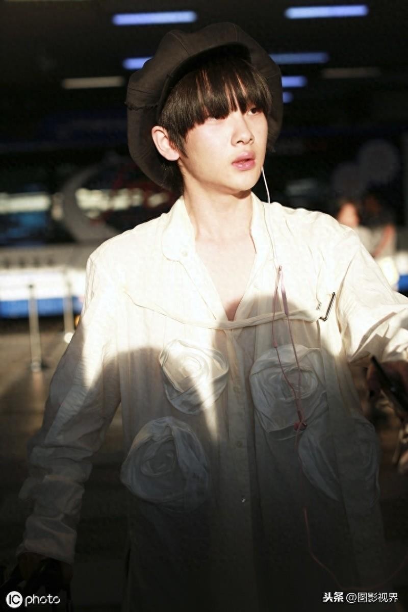 男歌手周震南现身机场，穿白衣服戴贝雷帽，涂黑色指甲油个性十足