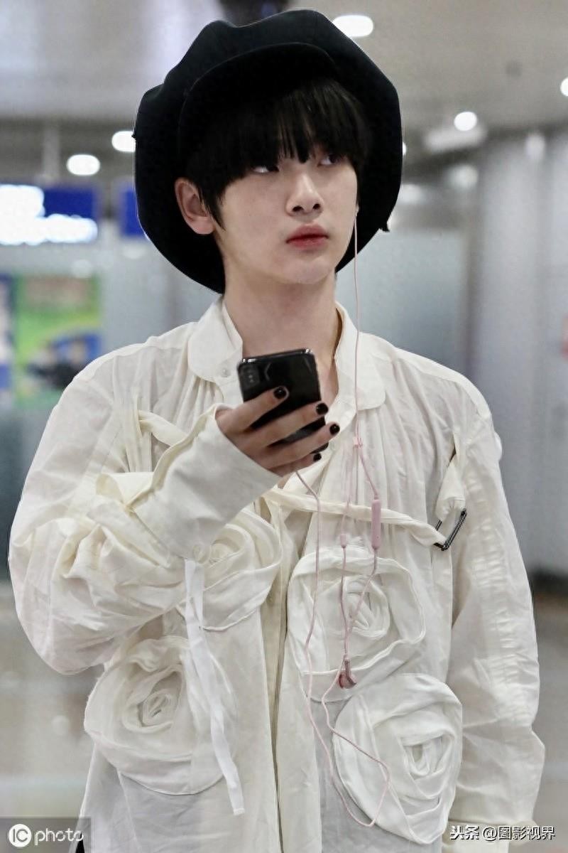男歌手周震南现身机场，穿白衣服戴贝雷帽，涂黑色指甲油个性十足