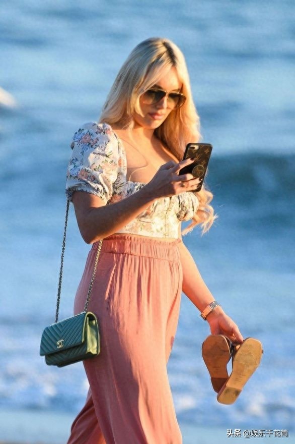 英国女演员现身海滩度假，身穿印花上衣搭粉色阔腿裤时尚靓丽迷人