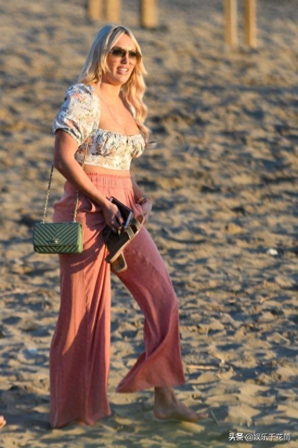 英国女演员现身海滩度假，身穿印花上衣搭粉色阔腿裤时尚靓丽迷人
